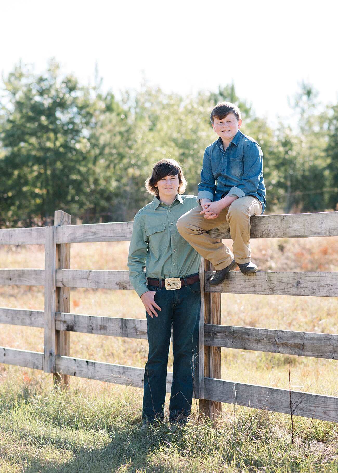 Two brothers posing together on country fence in Aiken