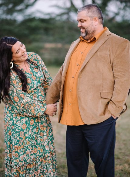 Husband and wife laugh during portrait session